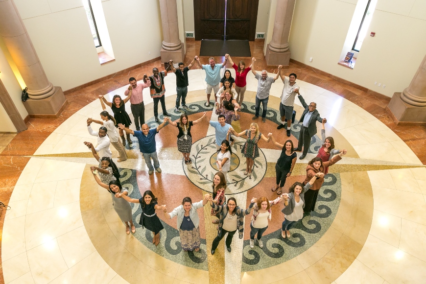 Students holding hands in the Kroc School rotunda to make a peace sign
