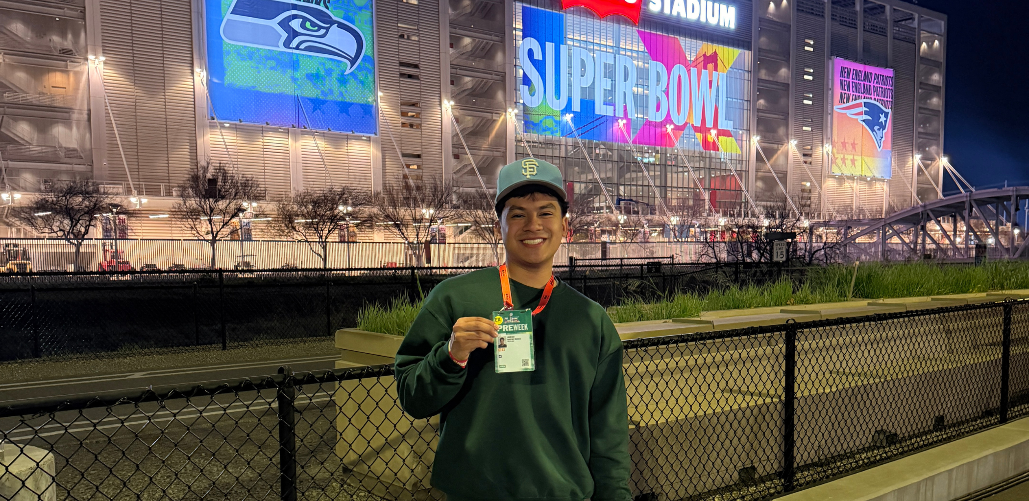 Jonathan Martinez Mancia ’25 (BA) holds up a pass outside of Levi Stadium in Santa Clara at Super Bowl LX.