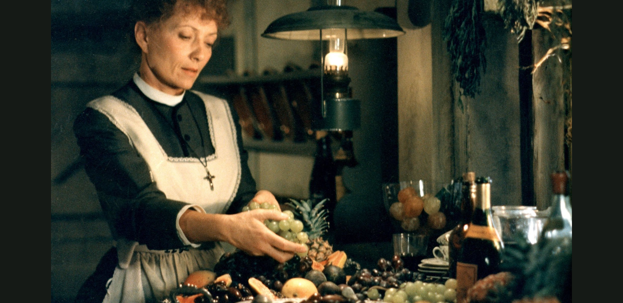 A still from the film Babette's Feast featuring Babette in the kitchen.