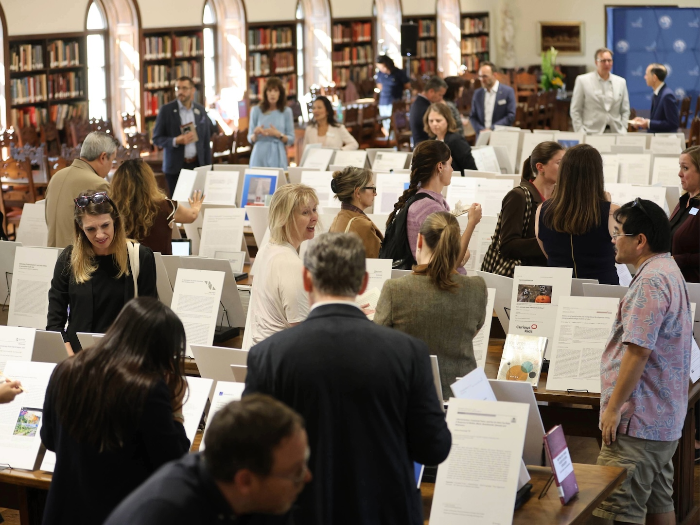 Faculty members reading displays of each others' work that was published in the last year.
