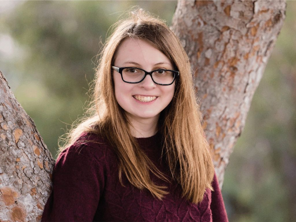 A headshot of Hannah Gagle against a tree.