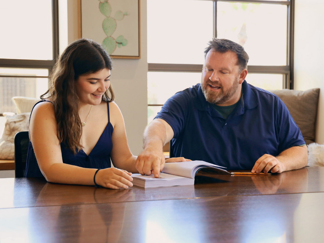 Student sitting at table with Honors Program director.