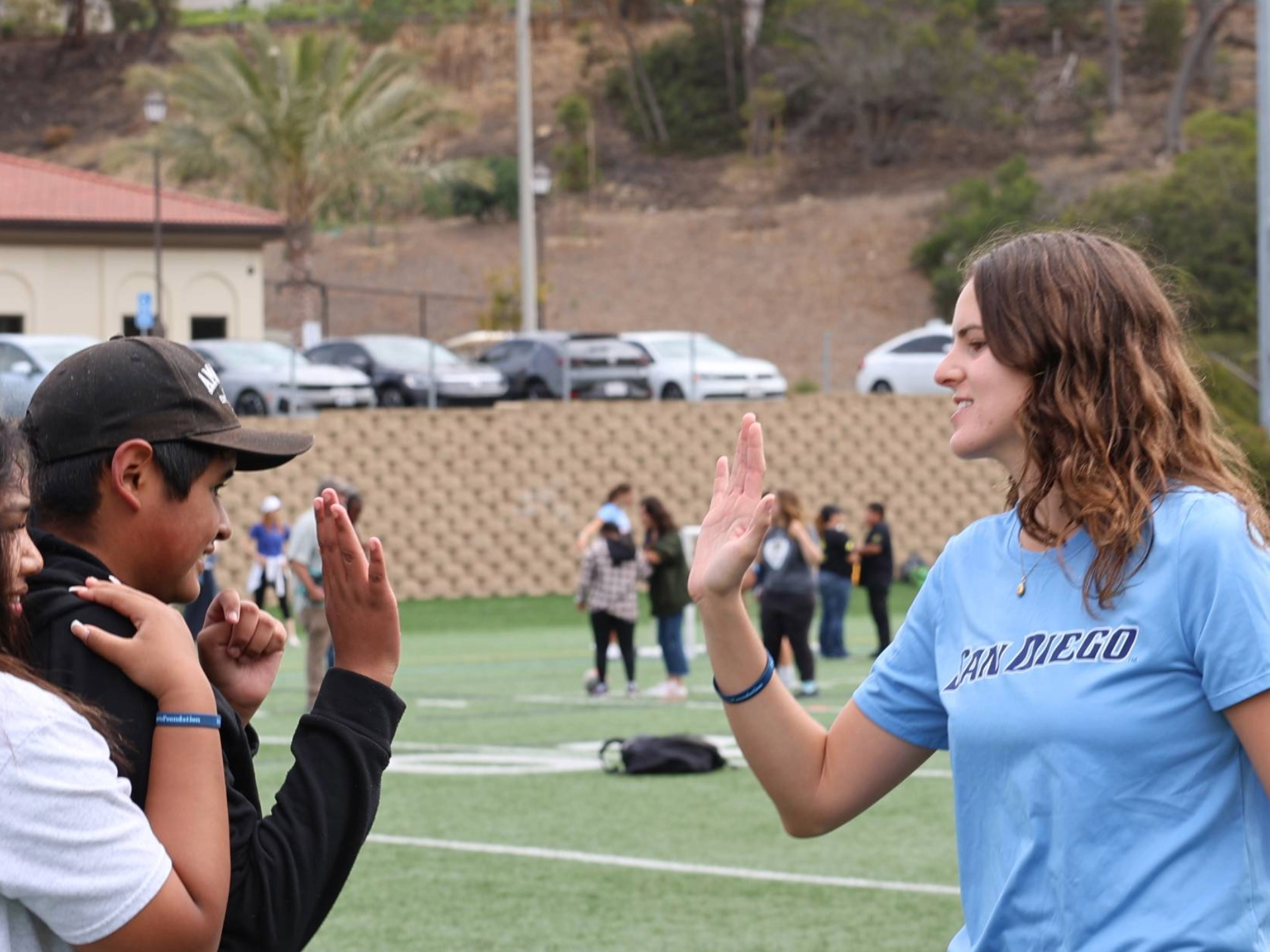 Torero student-athlete high-fiving a student at Inclusive Sports Day