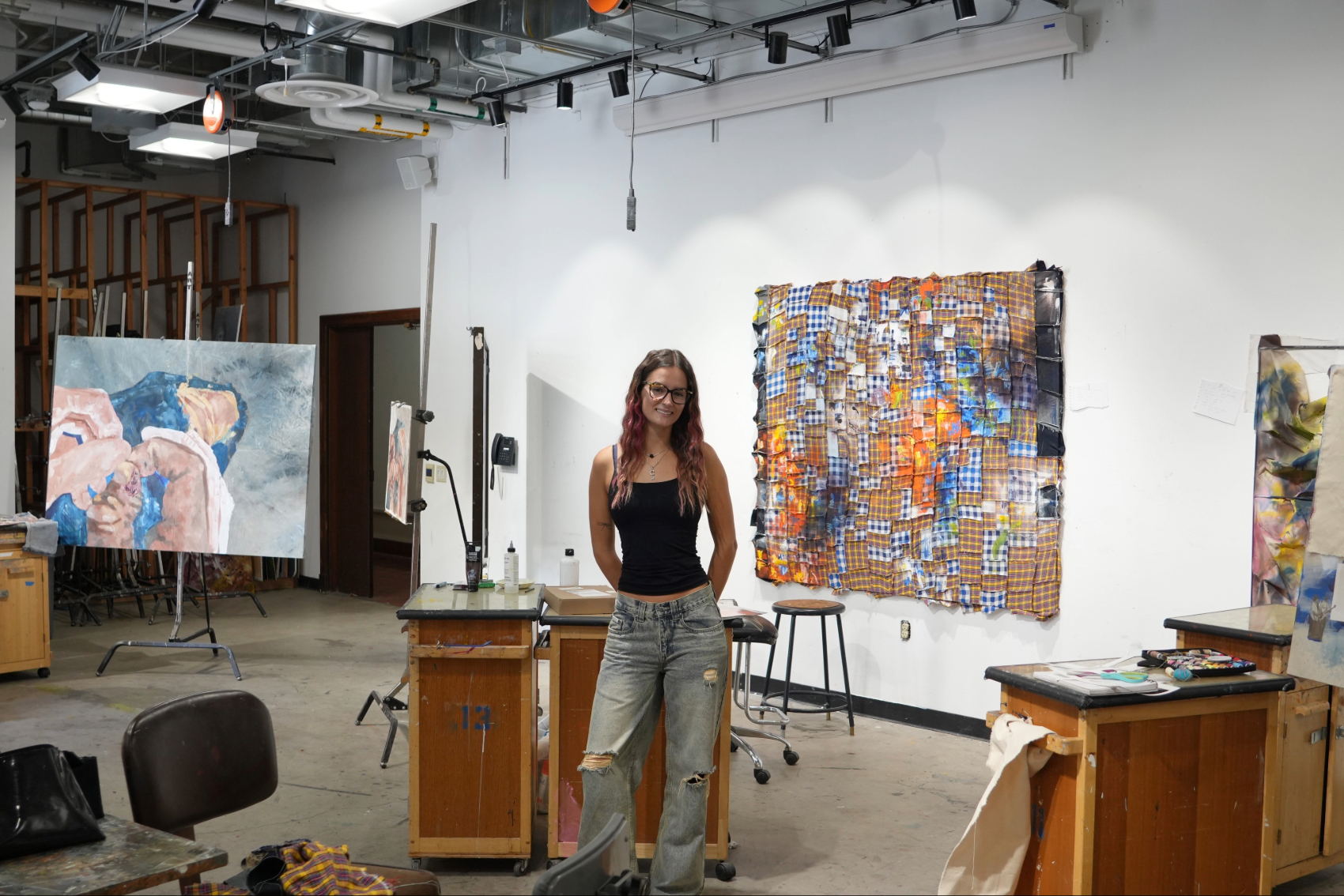 Callie Schreiber in the art studio in front of her pieces.