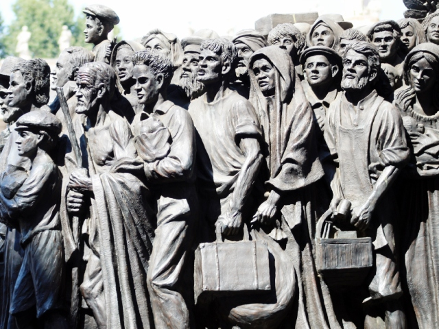 Photograph of a portion of "Angels Unaware" by artist Timothy Schmalz, a bronze piece depicting 140 migrants and refugees from various cultures and historical periods huddled together on a boat.