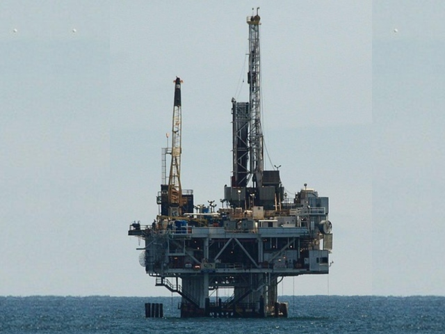 Photograph of an offshore oil rig’s steel structure above the ocean waves.