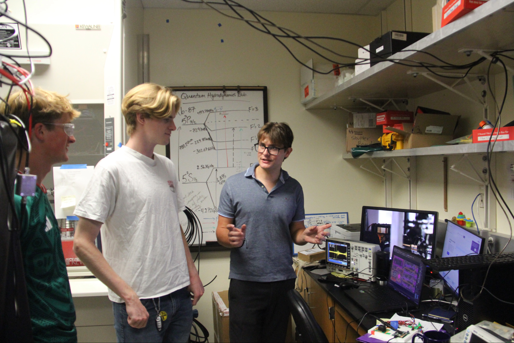 Parker Osborne explaining his project to fellow lab mates.