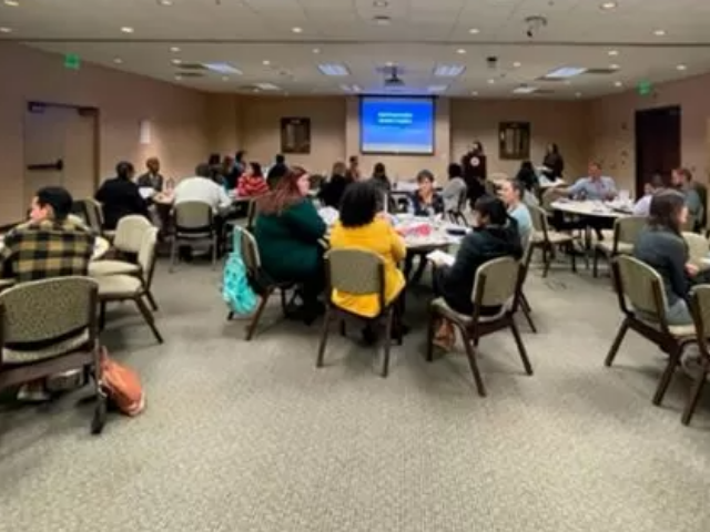Participants sitting at round tables for a workshop.