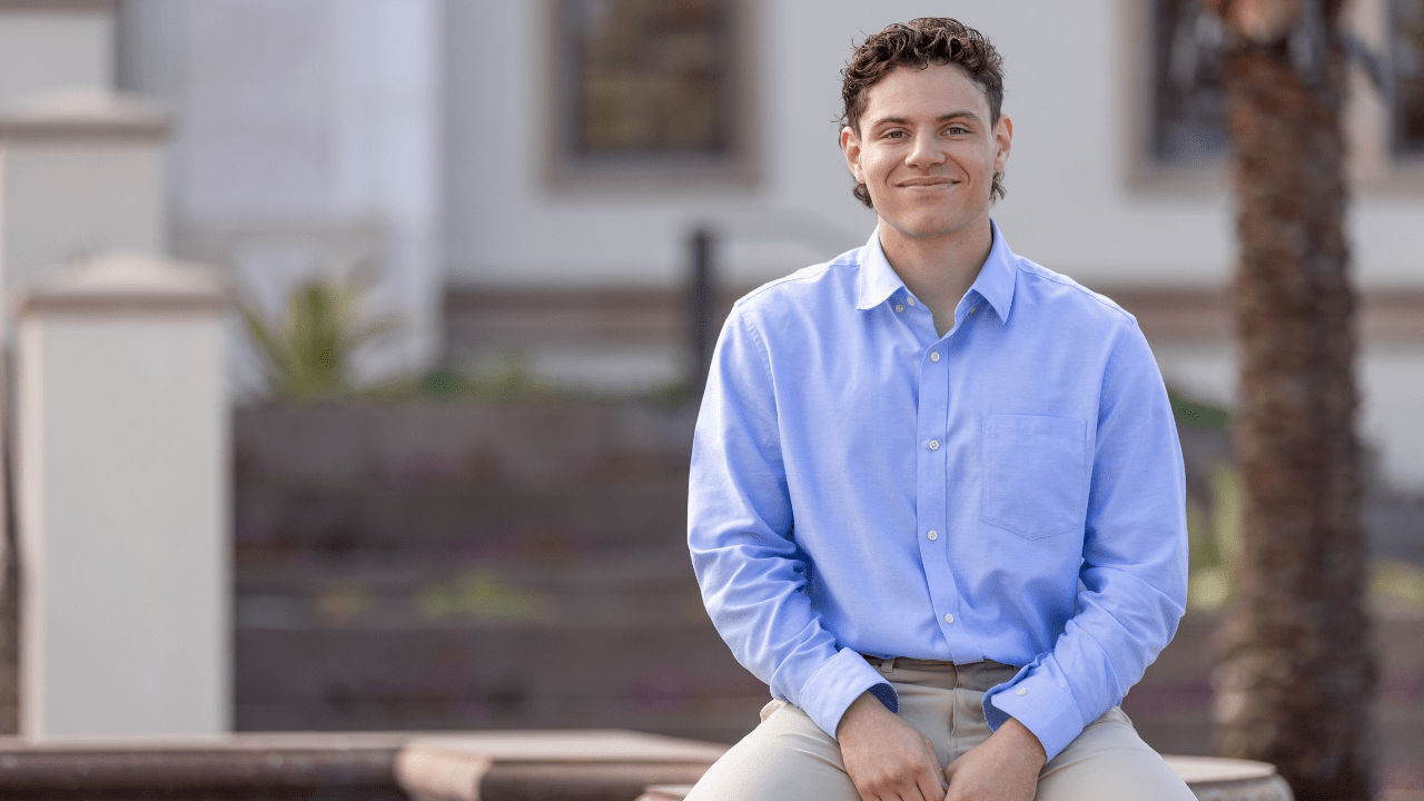 Dominyck Bullard, founder of Athletiverse, sits in front of Knauss School of Business.