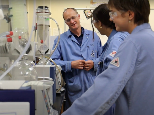 Dr. Tim Clark and two students standing in a chemistry lab at USD