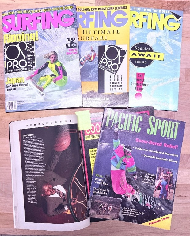 Five magazines are laid out on a table. The top three covers read "Surfing," the bottom left has a photograph of a man playing basketball in a suit, and the right reads "Pacific Sport" with a snowboarder on the front.