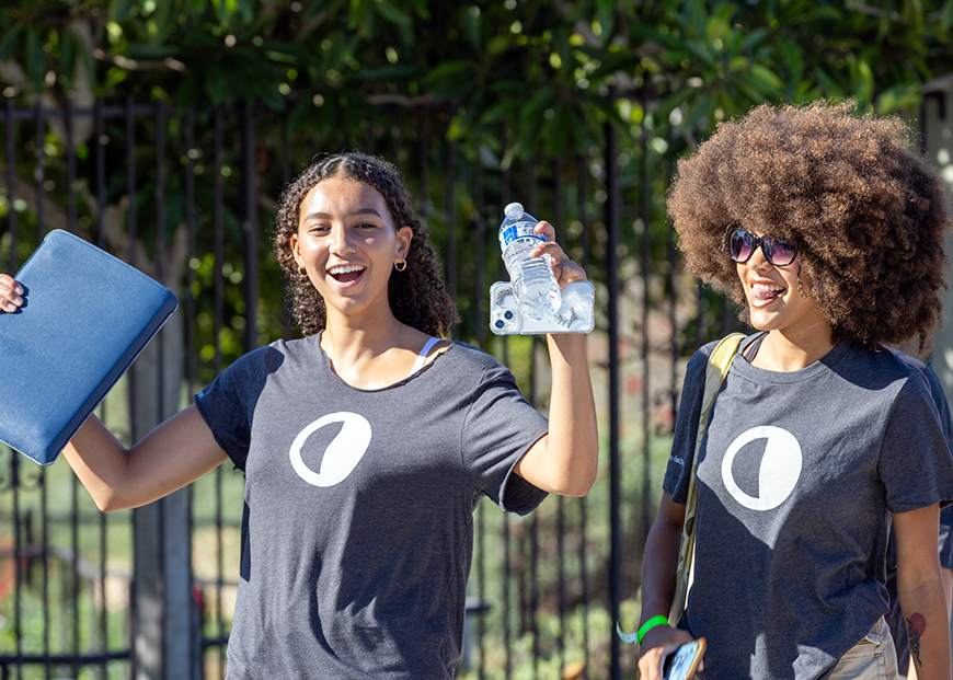 Two new students cheer as they walk towards the Jenny Craig Pavilion for New Student Convocation on Tuesday, Aug. 29, 2023. (Photo by Matthew Piechalak)